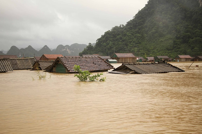 Người dân Tân Hóa chật vật trong những ngày mưa lũ. 