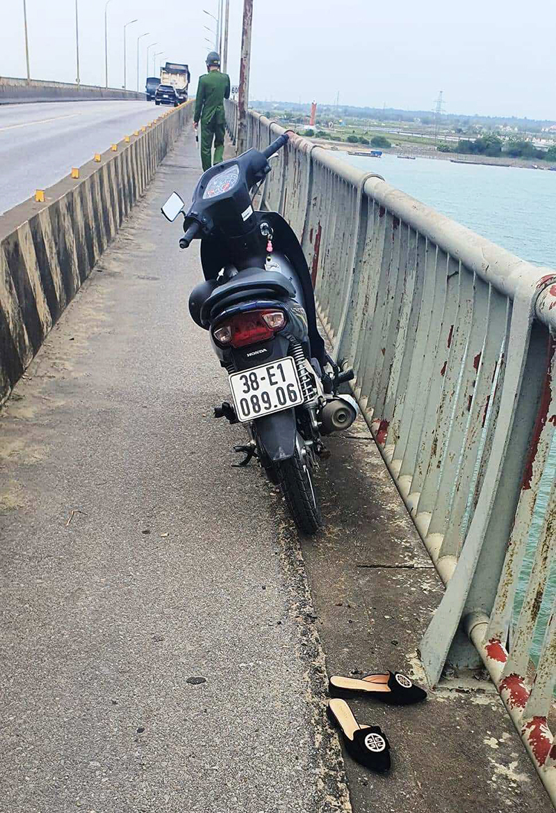 Chiếc xe máy trên cầu, bên cạnh là đôi dép nghi của người phụ nữ nhảy cầu tự tử.
