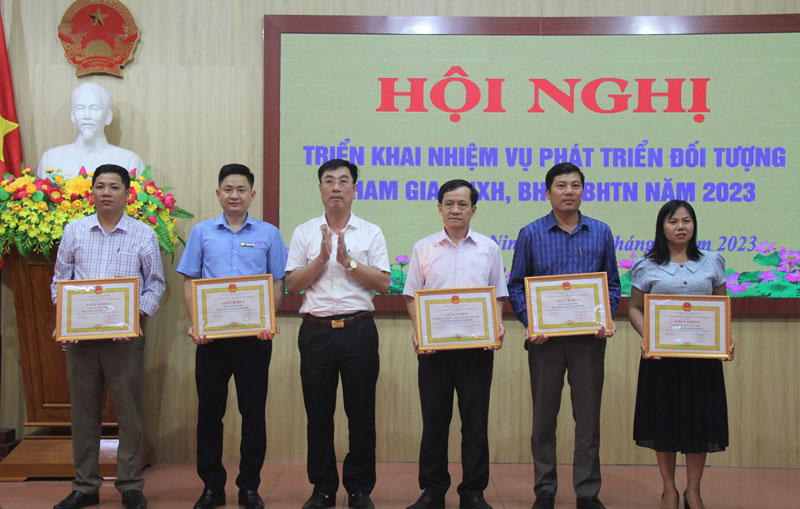 Đại diện lãnh đạo huyện Quảng Ninh tặng giấy khen cho các tập thể có thành tích xuất sắc trong công tác phát triển BHXH tự nguyện, BHYT năm 2022.