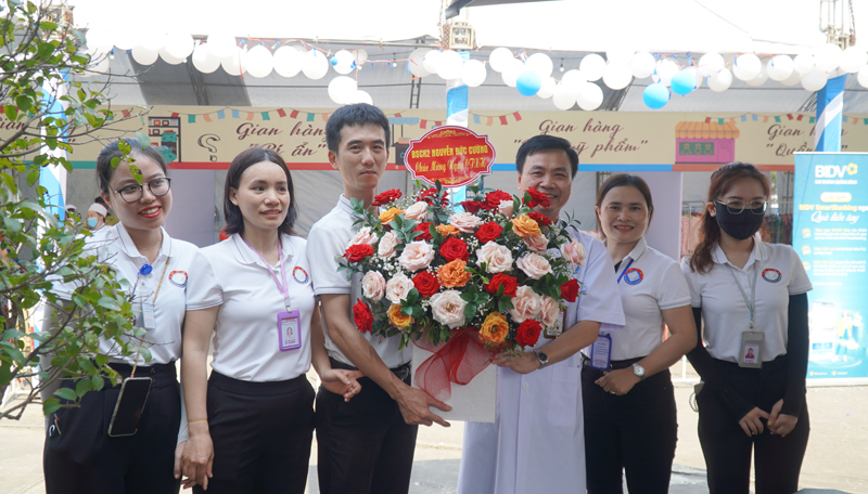 Bác sĩ Nguyễn Đức Cường, Giám đốc Bệnh viện Hữu nghị Việt Nam - Cuba Đồng Hới tặng hoa chúc mừng đội công tác xã hội của bệnh viện đã nỗ lực tổ chức “Hội chợ 0 đồng”cho bệnh nhân.