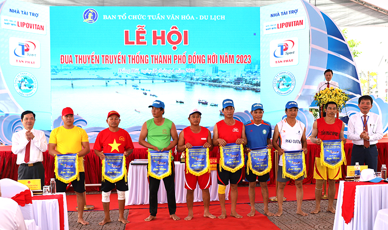 Chủ tịch UBND TP. Đồng Hới Hoàng Ngọc Đan trao cờ lưu niệm các đội thuyền. 