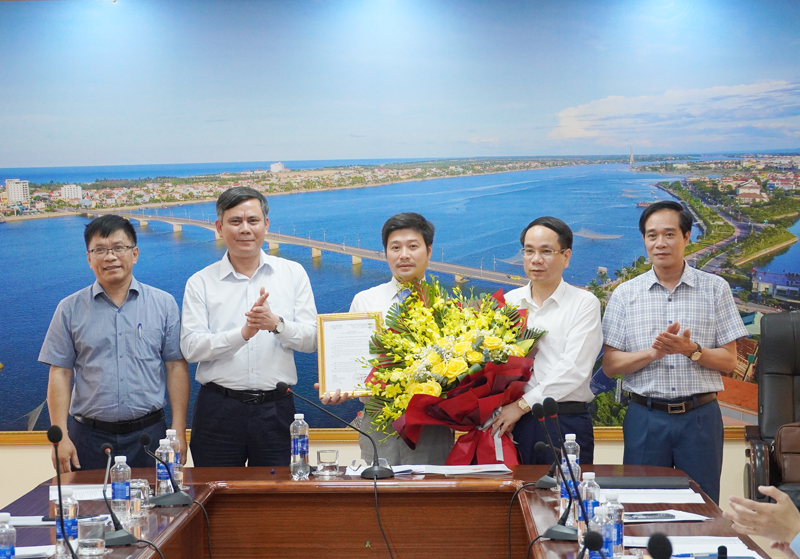 Đồng chí Chủ tịch UBND tỉnh Trần Thắng và đồng chí Phó Chủ tịch UBND tỉnh Phan Mạnh Hùng trao quyết định, tăng hoa chúc mừng tân Giám đốc Sở Xây dựng Lê Anh Đức.