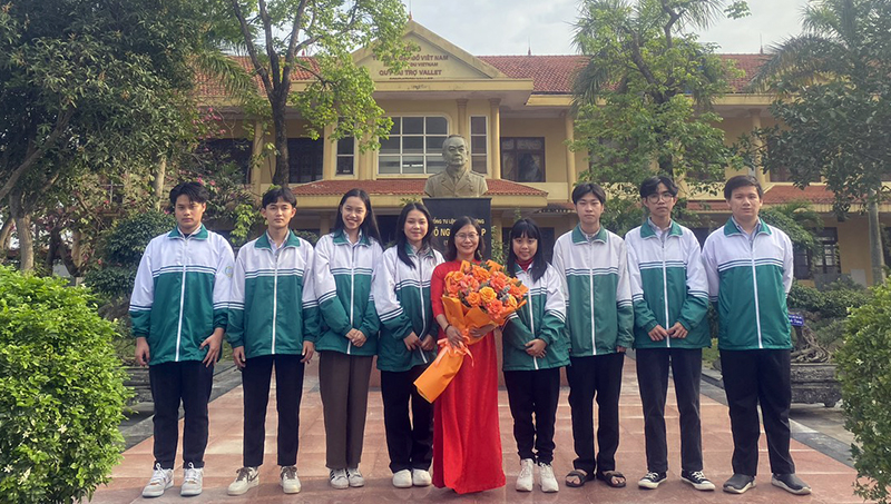 Bùi Quang Hà (người đầu tiên từ bên trái qua) chụp ảnh lưu niệm cùng cô giáo chủ nhiệm đội tuyển và các thành viên.