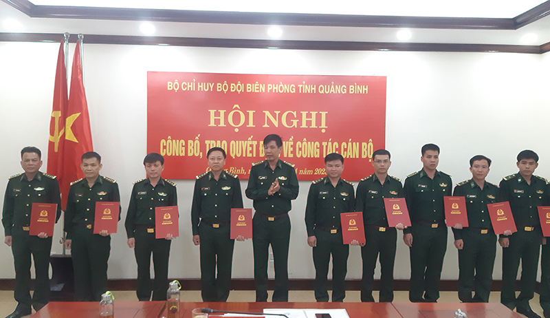 Đại tá Lê Văn Tiến, Bí thư Đảng ủy, Chính ủy trao quyết định các đồng chí được thăng quân hàm, điều động, bổ nhiệm chức vụ mới.