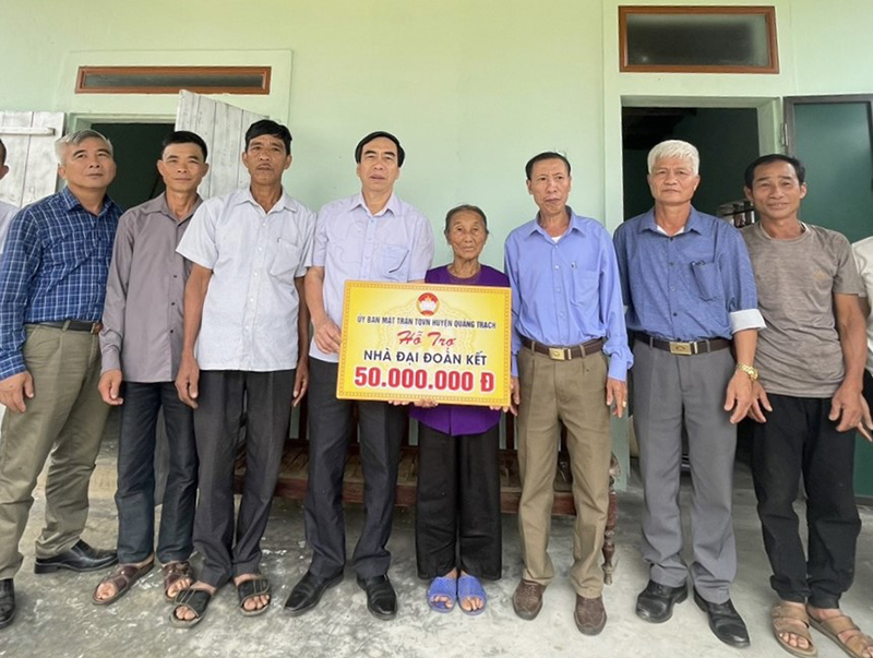 Lãnh đạo Ủy ban MTTQVN huyện Quảng Trạch trao số tiền hỗ trợ xây dựng nhà “Đại đoàn kết” cho bà Phạm Thị Hồng.