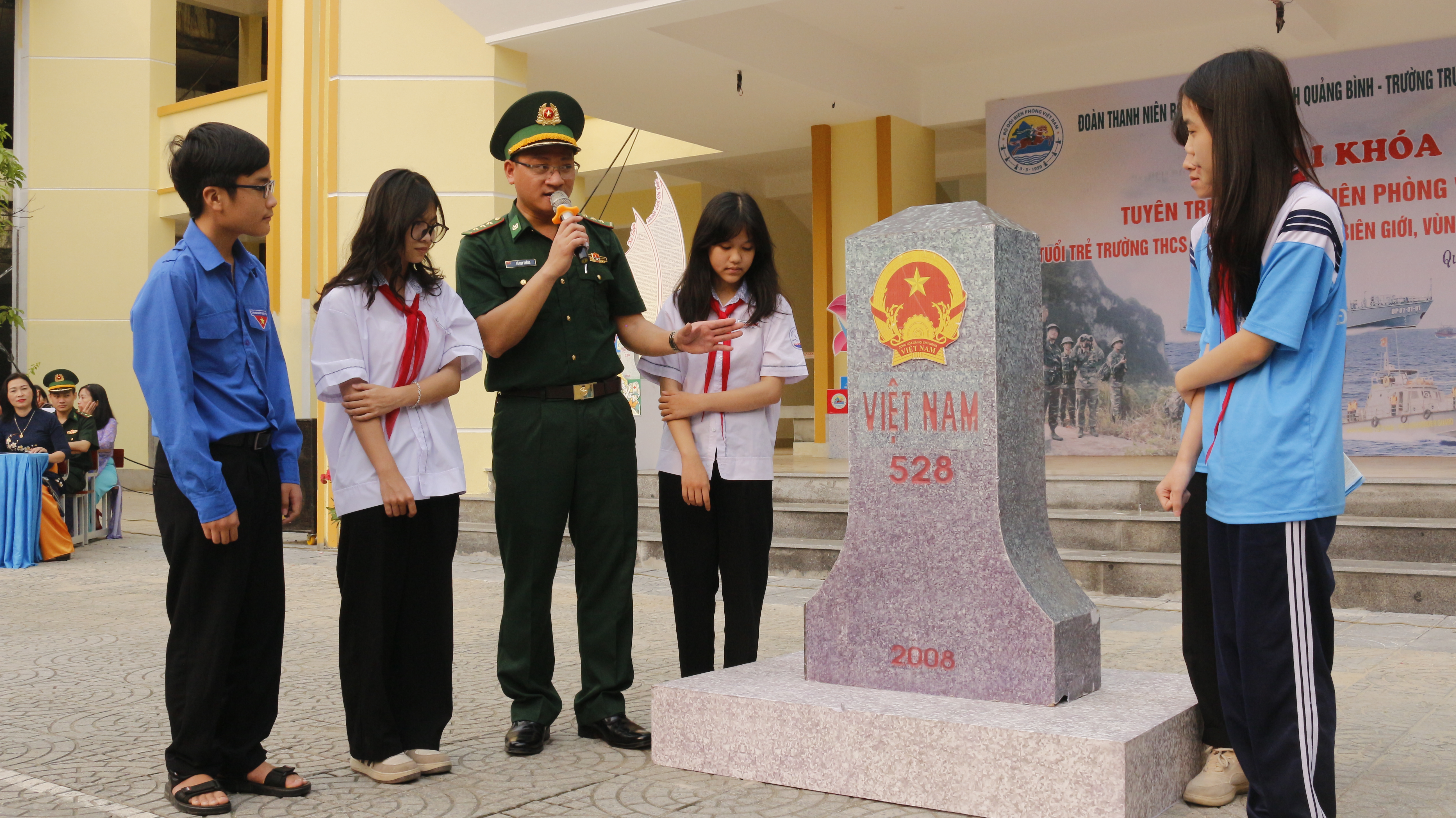 Thượng úy Võ Huy Thắng giới thiệu mô hình cột mốc quốc giới cho học sinh Trường THCS Đồng Mỹ (TP. Đồng Hới).