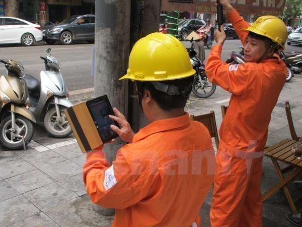 Nhân viên EVN ghi chỉ số côngtơ điện. (Ảnh: Xuân Quảng/Vietnam+)