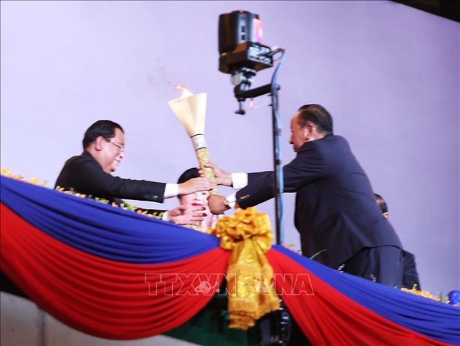 Thủ tướng Campuchia Samdech Techo Hun Sen trao ngọn đuốc Đại hội cho Phó Thủ tướng Campuchia Samdech Tea Banh - Chủ tịch Uỷ ban Tổ chức SEA Games 32. Ảnh: Hoàng Linh/TTXVN