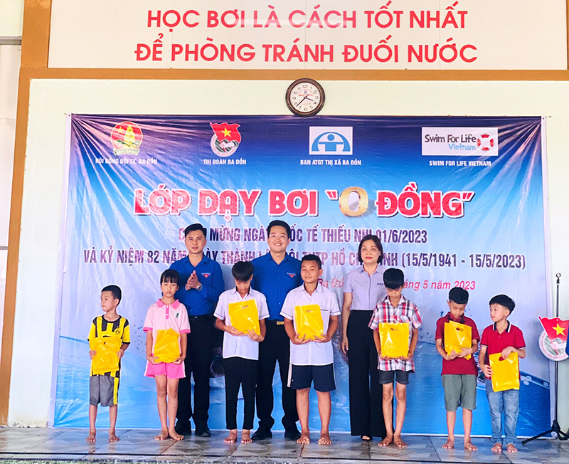 Ban tổ chức trao quà (dụng cụ học bơi) cho các em thiếu nhi thuộc gia đình hộ nghèo tham gia khóa học.