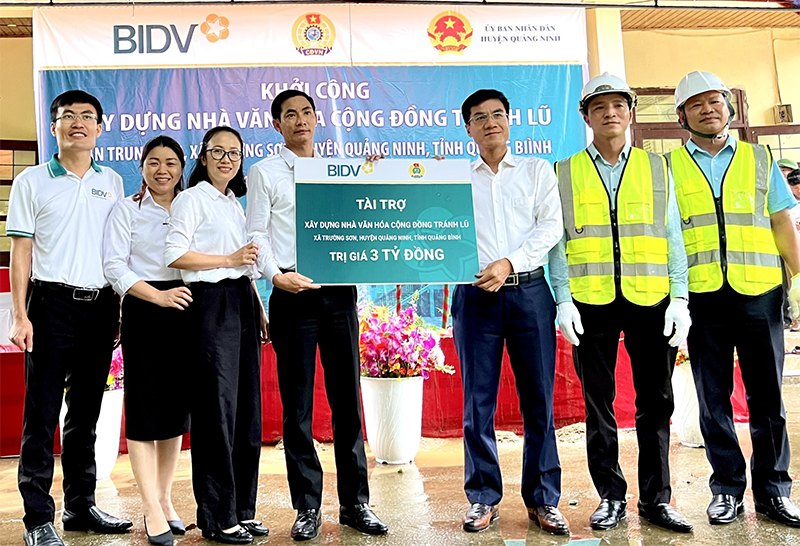 Đại diện lãnh đạo BIDV trao số tiền hỗ trợ xây dựng nhà văn hóa cộng đồng tránh lũ tại bản Trung Sơn cho UBND huyện Quảng Ninh.