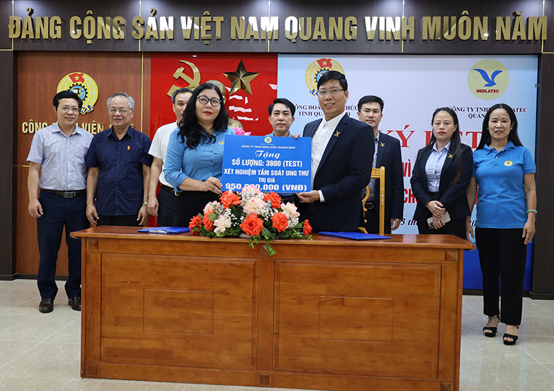 Đại diện lãnh đạo Công ty TNHH Medlatec Quảng Bình trao tượng trưng hỗ trợ 3.800 test xét nghiệm tầm soát nguy cơ ung thư cho CĐVC tỉnh.