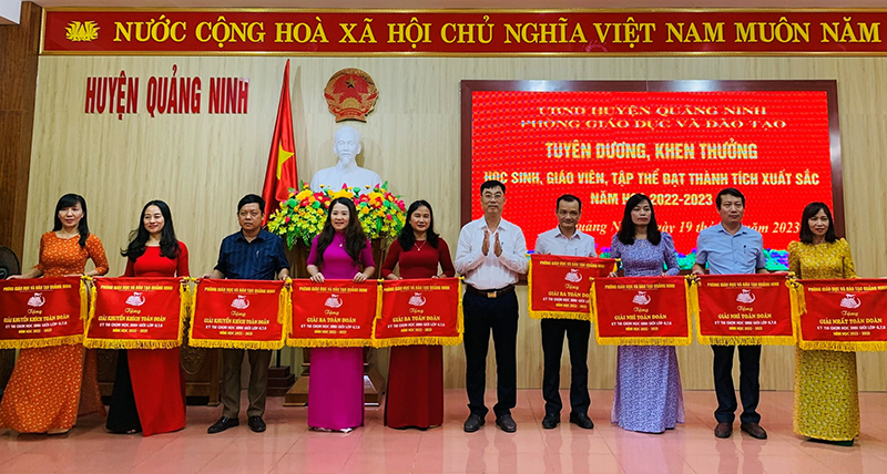 Lãnh đạo huyện Quảng Ninh tặng cờ cho các tập thể có thành tích xuất sắc trong bồi dưỡng học sinh giỏi.