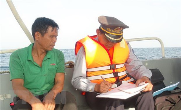 Lực lượng kiểm ngư Quảng Bình tuyên truyền cho ngư dân đang khai thác trên biển tuân thủ các quy định pháp luật về chống khai thác IUU. (Ảnh: Đức Thọ/TTXVN)
