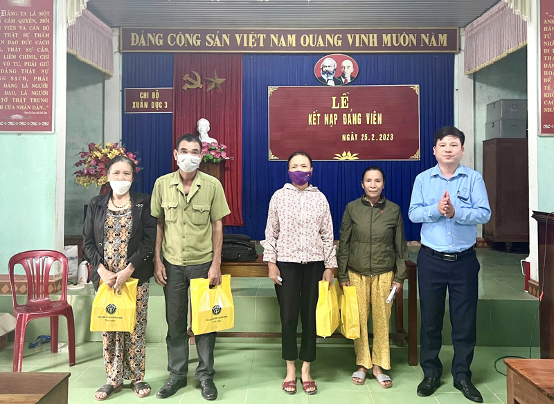 Đại diện lãnh đạo BHXH huyện Quảng Ninh trao ấn phẩm tuyên truyền cho người dân.