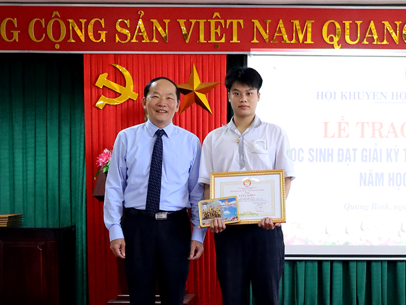 Chủ tịch Hội Hội Khuyến học tỉnh Trần Xuân Vinh trao thưởng cho em Bùi Quang Hà, đạt giải nhất môn Lịch sử.