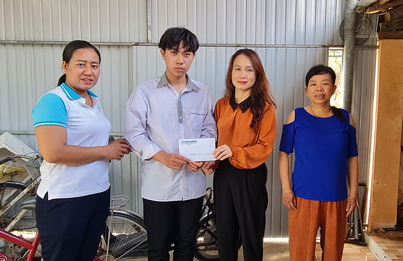 Đại diện Báo Quảng Bình và chính quyền địa phương trao tiền hỗ trợ cho em Nguyễn Trung Kiên.