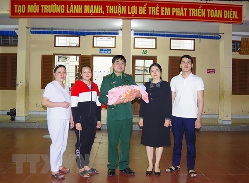 Đại diện Bộ đội Biên phòng tỉnh Cao Bằng phá chuyên án mua bán người dưới 16 tuổi và bàn giao cháu bé cho cơ quan bảo trợ xã hội địa phương. Ảnh: TTXVN  