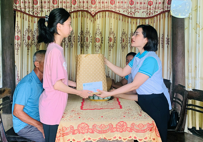 Hội LHPN huyện Quảng Ninh tặng quà và trao tiền cho em Nguyễn Thị Hải Yến, thôn Thế Lộc, xã Tân Ninh.