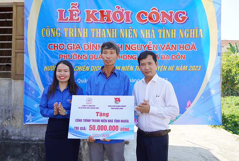 Đại diện lãnh đạo Công ty TNHH MTV Xổ số kiến thiết Quảng Bình và Đoàn Khối DN tỉnh tặng biển tượng trưng hỗ trợ tiền xây nhà cho anh Nguyễn Văn Hòa (phường Quảng Phong, TX. Ba Đồn).