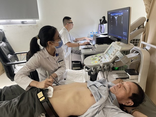 Nhân viên y tế thực hiện siêu âm ổ bụng cho một bệnh nhân. (Ảnh: PV/Vietnam+)