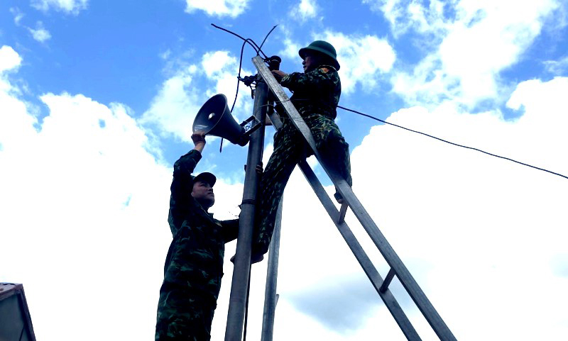 Cán bộ, chiến sĩ Đồn Biên phòng Cà Roòng, BĐBP tỉnh dựng cột và lắp đặt hệ thống loa trong mô hình “Truyền thanh bản xa”.