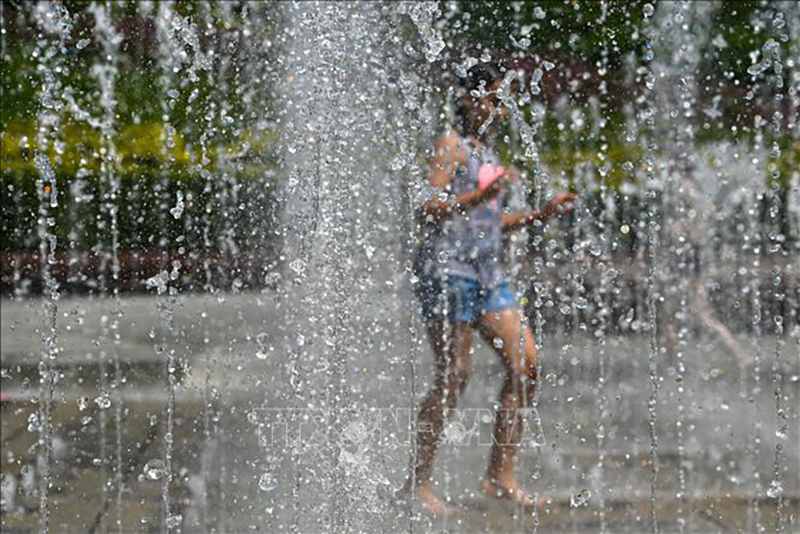 Trẻ em làm mát tại đài phun nước ở Rzeszow, Ba Lan ngày 20/6/2023. Ảnh: AFP/TTXVN