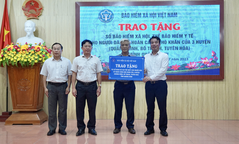 Tổng Giám đốc BHXH Việt Nam Nguyễn Thế Mạnh trao biển tượng trưng 150 sổ BHXH, 540 thẻ BHYT cho các huyện Quảng Ninh, Bố Trạch, Tuyên Hóa.