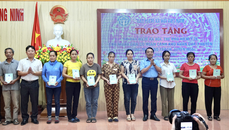 Đại diện lãnh đạo BHXH tỉnh và huyện Quảng Ninh trao tặng thẻ BHYT, sổ BHXH cho người dân có hoàn cảnh khó khăn trên địa bàn huyện Quảng Ninh.