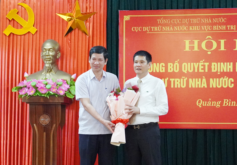 Đồng chí Phó Chủ tịch UBND tỉnh Hồ An Phong tặng hoa chúc mừng Cục trưởng Cục DTNN khu vực Bình Trị Thiên Lê Quang Thành.
