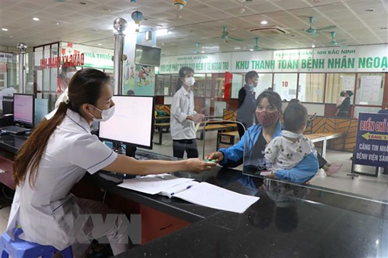 Bác sỹ Bệnh viện Sản-Nhi Bắc Ninh phát thẻ khách hàng cho bệnh nhân đến khám. (Ảnh: Thanh Thương/TTXVN)