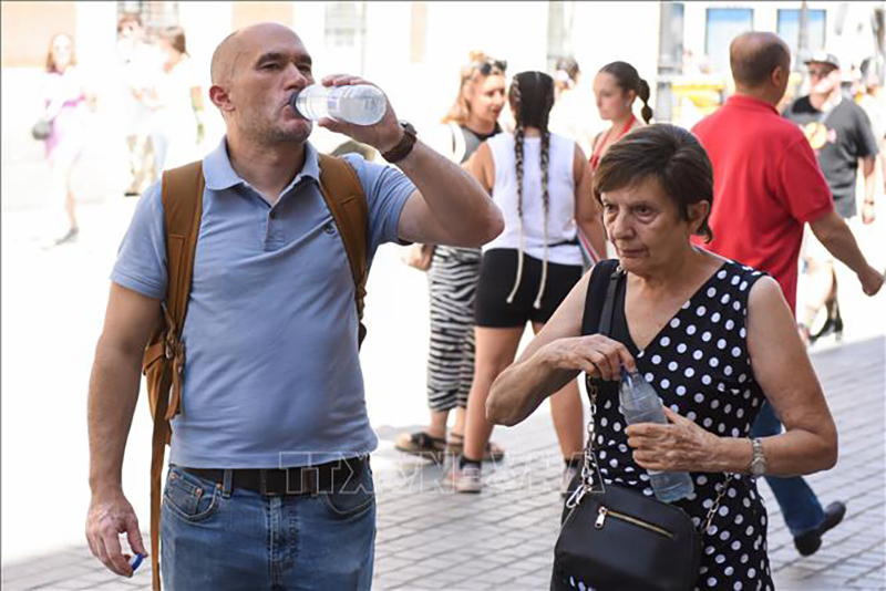  Người dân uống nước giải nhiệt tại Madrid, Tây Ban Nha, ngày 10/7/2023. Ảnh: THX/TTXVN