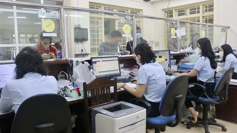 Cán bộ BHXH tỉnh thực hiện các thủ tục hành chính để cấp sổ BHXH, thẻ BHYT cho người tham gia.