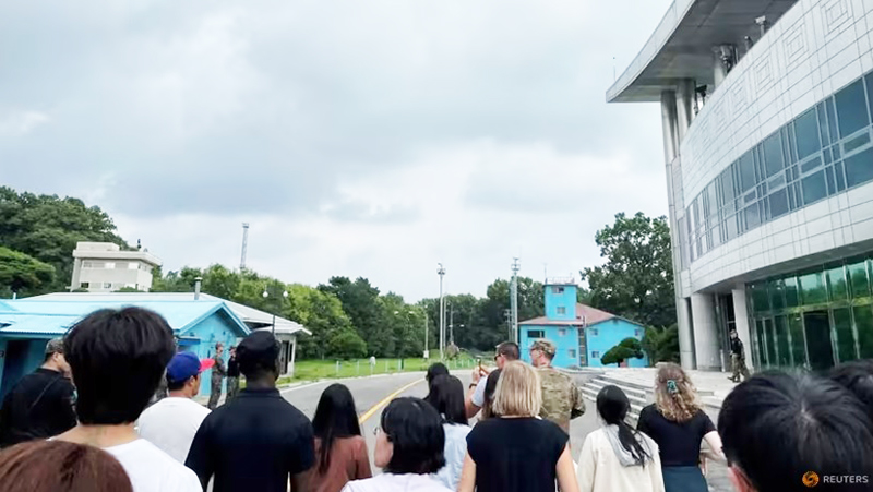  Quân nhân Travis T. King (mặc áo đen và đội mũ) tham gia tour tham quan JSA. Ảnh: Reuters 