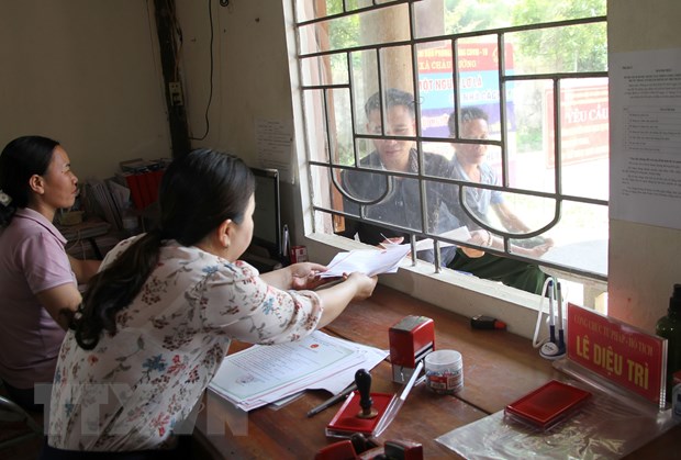 Cán bộ làm việc tại Hệ thống một cửa xã miền núi Châu Cường, huyện Quỳ Hợp (Nghệ An) giải quyết các thủ tục hành chính cho người dân. (Ảnh: Văn Tý/TTXVN)