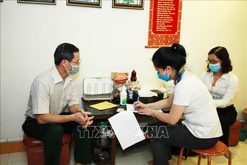 Bưu điện kết hợp với Bảo hiểm xã hội thành phố Hà Nội tổ chức chi trả lương hưu tại nhà. Ảnh: TTXVN phát