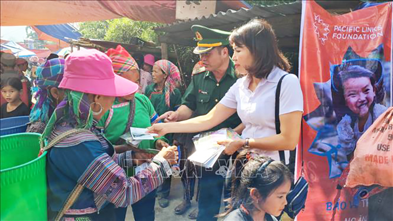 Phát tờ rơi tuyên truyền về phòng, chống mua bán người cho phụ nữ dân tộc thiểu số tại chợ trung tâm xã Tả Gia Khâu, huyện Mường Khương, tỉnh Lào Cai. Ảnh: Hương Thu/TTXVN