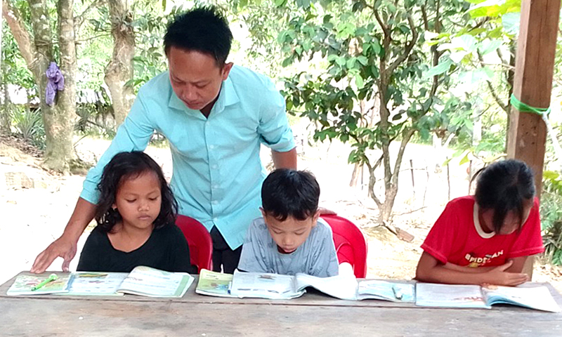 Thầy giáo Hồ Tiến Nam dạy chữ cho con em vùng đồng bào Rục trong dịp nghỉ hè.