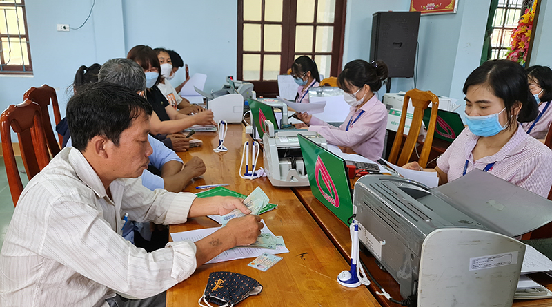 Người dân làm thủ tục nhận vốn vay ưu đãi tại các điểm giao dịch xã.