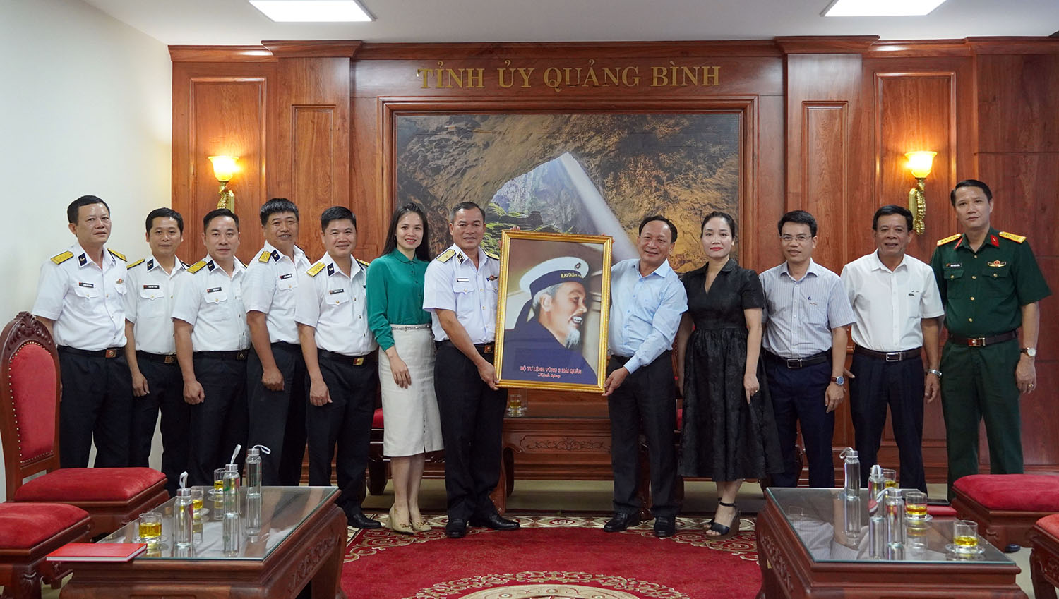 Chuẩn đô đốc Nguyễn Đăng Tiến và đồng chí Phó Bí thư Thường trực Tỉnh ủy Trần Hải Châu trao quà, chụp ảnh lưu niệm cùng các đại biểu