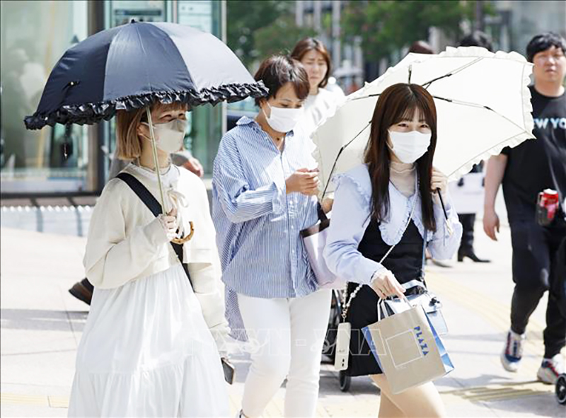 Người dân che ô tránh nắng nóng tại Fukuoka, Nhật Bản. Ảnh: Kyodo/TTXVN