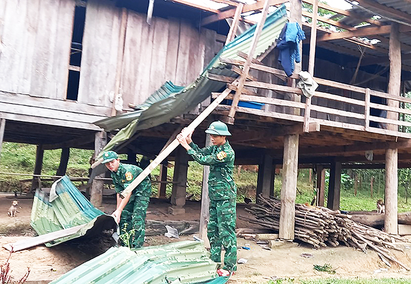 Cán bộ, chiến sỹ Đồn Biên phòng Ra Mai hỗ trợ nhân dân khắc phục thiệt hại do lốc xoáy.