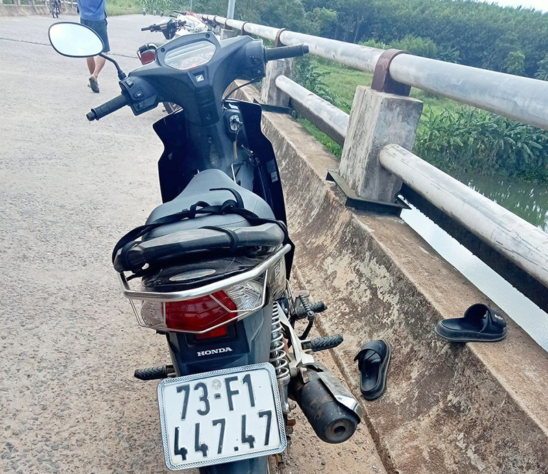 Chiếc xe gắn máy và đôi dép nạn nhân để lại trên cầu sông Dinh.