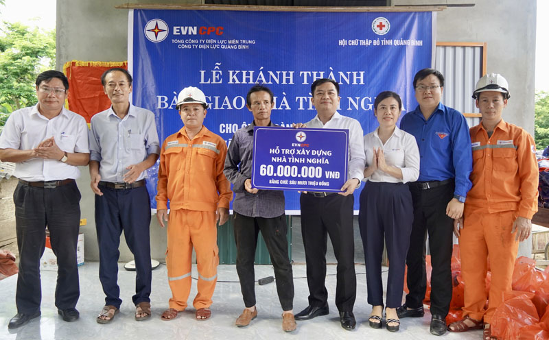 Đại diện lãnh đạo Công ty Điện lực Quảng Bình trao biển tượng trưng hỗ trợ 60 triệu đồng xây nhà tình nghĩa cho ông Hoàng Văn Tiến.