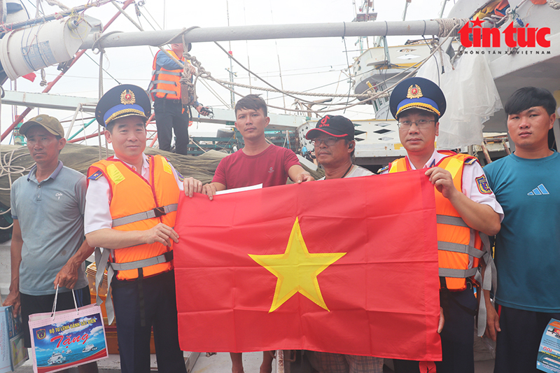 Trung tướng Bùi Quốc Oai - Chính ủy Cảnh sát biển tặng cờ Tổ quốc cho các tàu cá ngư dân đang neo đậu tại cảng cá xã đảo Thổ Châu, tỉnh Kiên Giang.