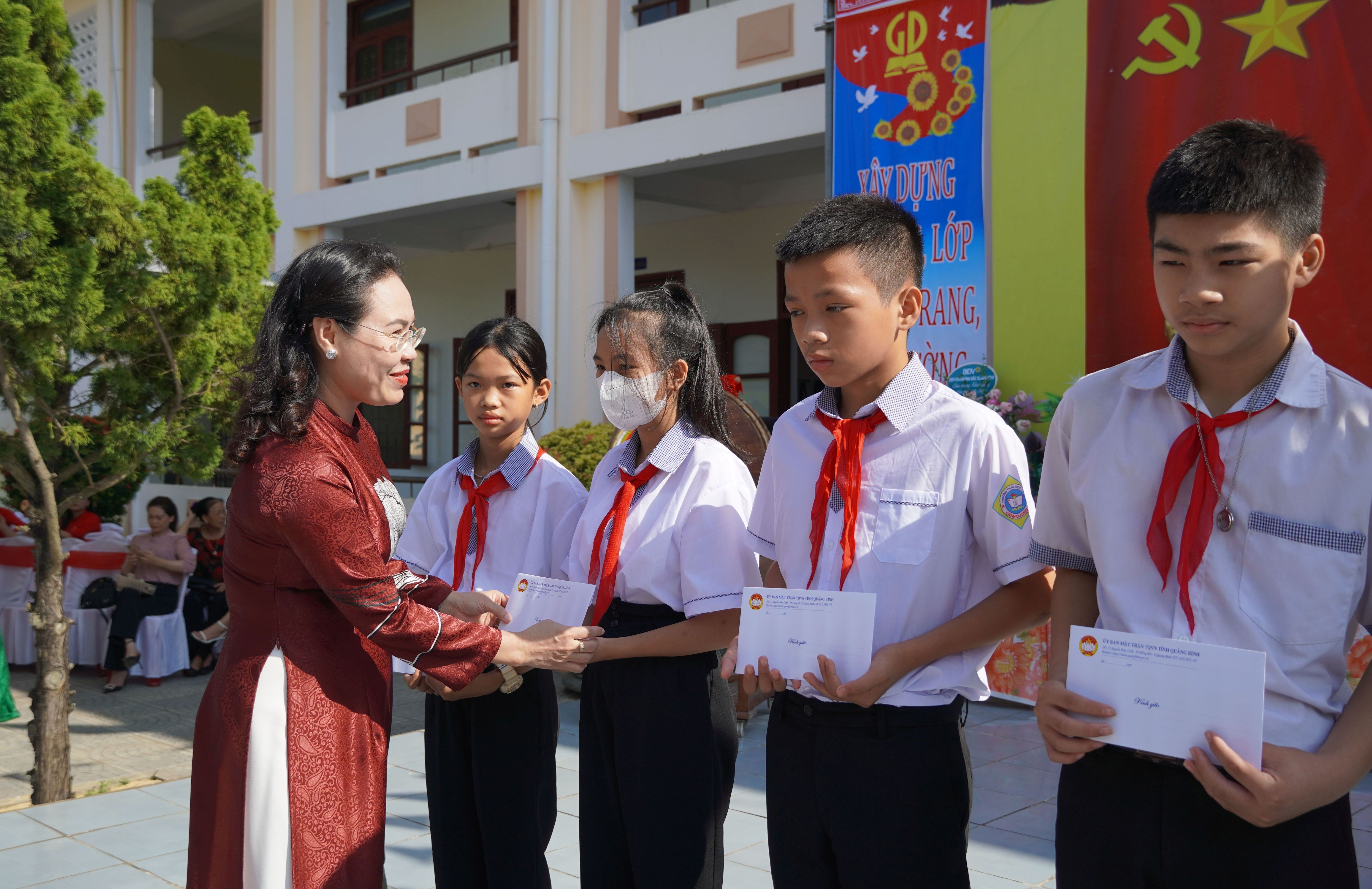 Đồng chí Chủ tịch Ủy ban MTTQVN tỉnh Phạm Thị Hân tặng quà cho các em học sinh Trường THCS Cảnh Dương.