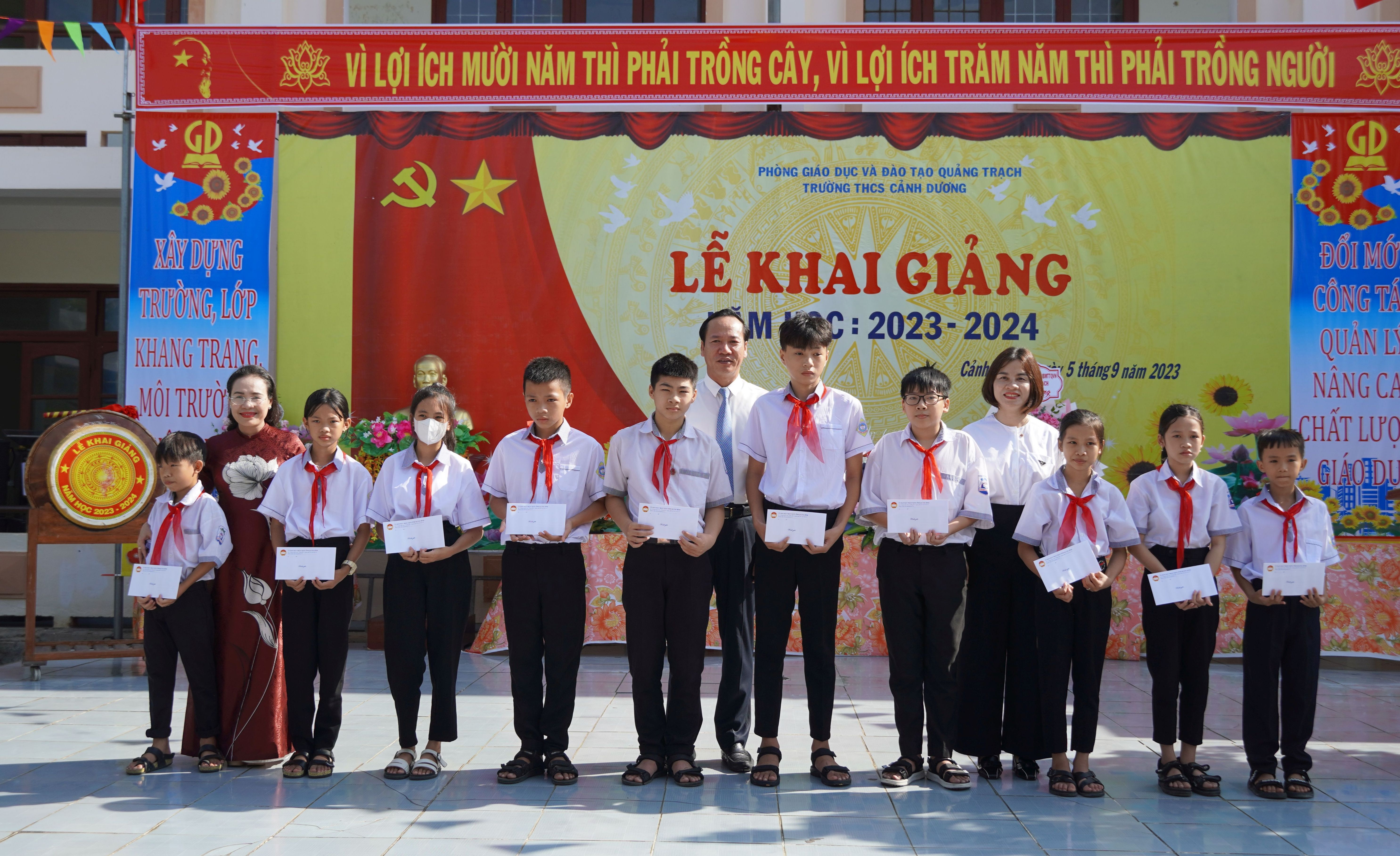 Đồng chí Chủ tịch Ủy ban MTTQVN tỉnh Phạm Thị Hân và lãnh đạo Hội LHPN tỉnh, huyện Quảng Trạch  tặng quà cho các em học sinh Trường THCS Cảnh Dương.