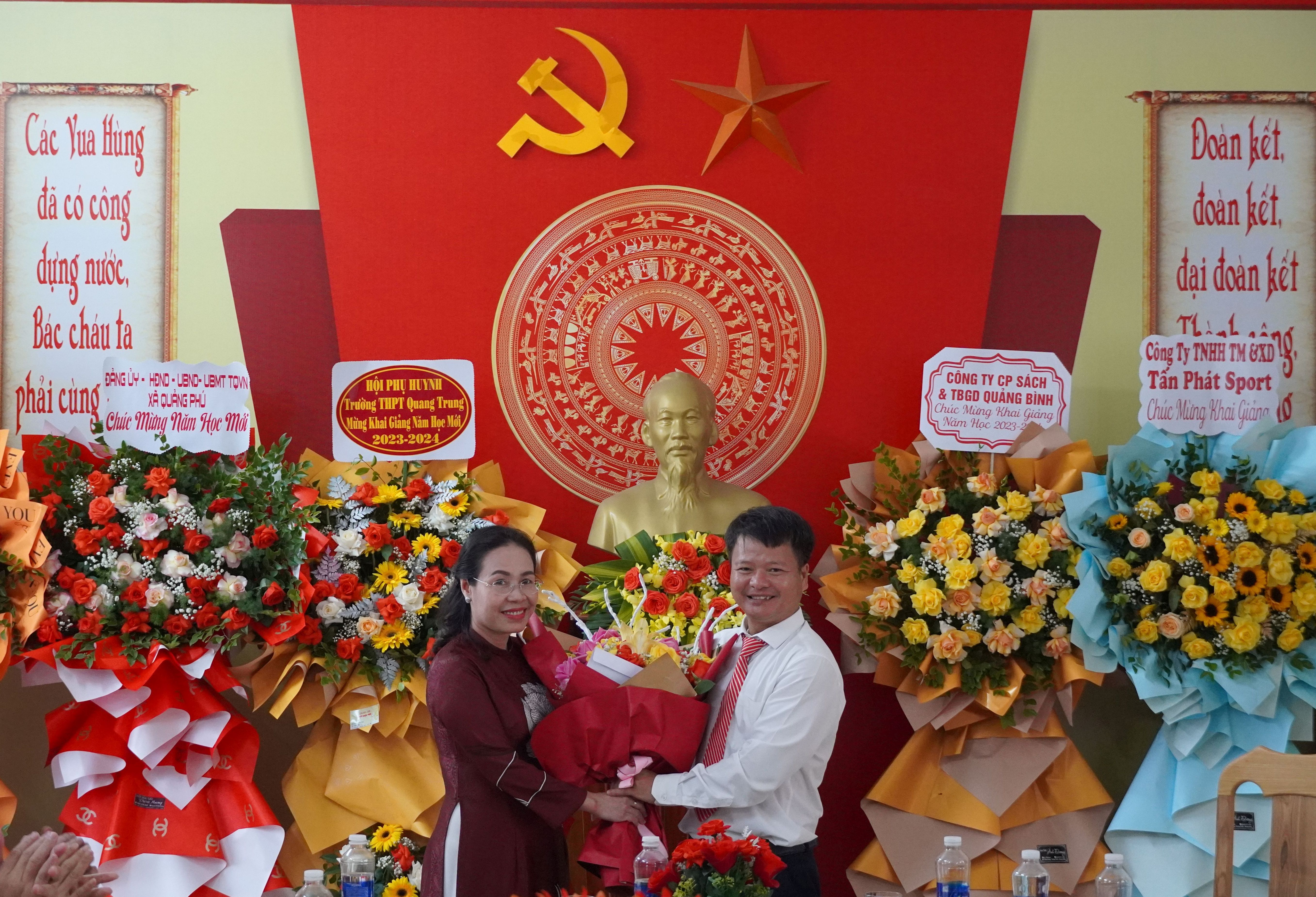 Đồng chí Chủ tịch Ủy ban MTTQVN tỉnh Phạm Thị Hân tặng hoa chúc mừng Trường PTTH Quang Trung. 