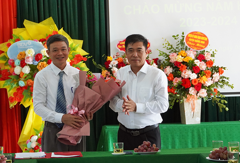 Đồng chí Phó Chủ tịch Thường trực UBND tỉnh Đoàn Ngọc Lâm tặng hoa chúc mừng cho Trường Phổ thông Dân tộc nội trú huyện Quảng Ninh.