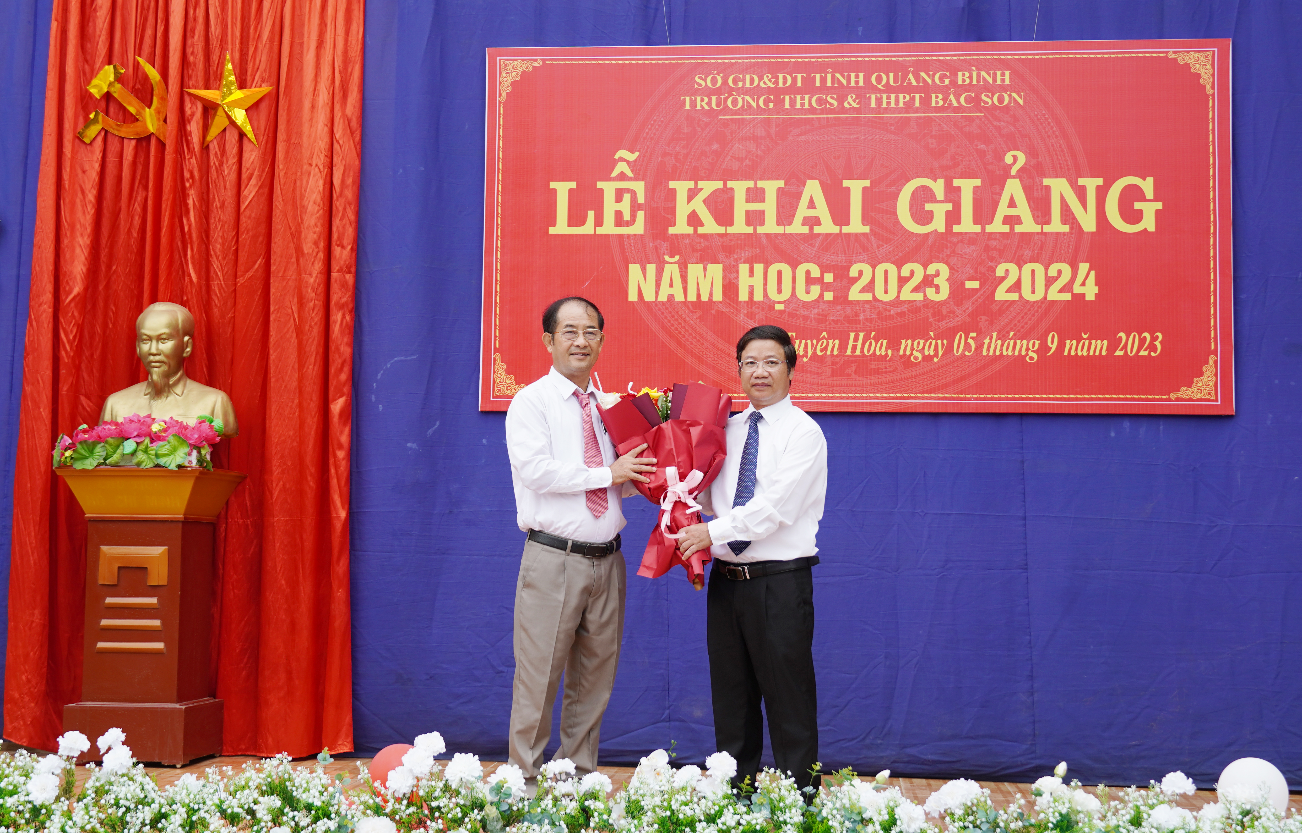 Đồng chí Trưởng ban Tuyên giáo Tỉnh ủy Cao Văn Định tặng hoa chúc mừng giáo viên và học sinh nhà trường.