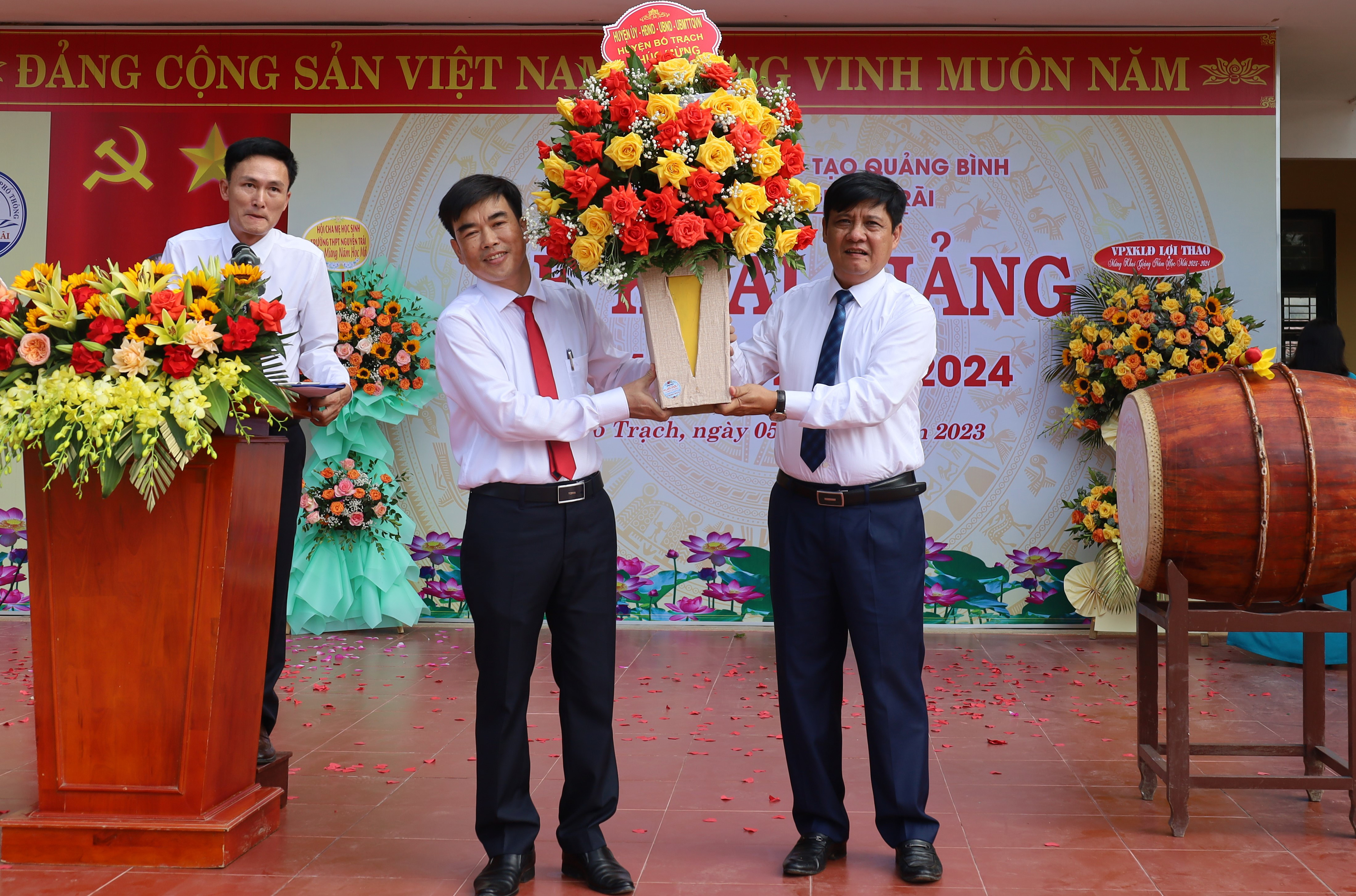 Đồng chí Bí thư Huyện Ủy Bố Trạch Lê Công Toán tặng hoa chúc mừng khai giảng năm học mới cho lãnh đạo Trường THPT Nguyễn Trãi. 
